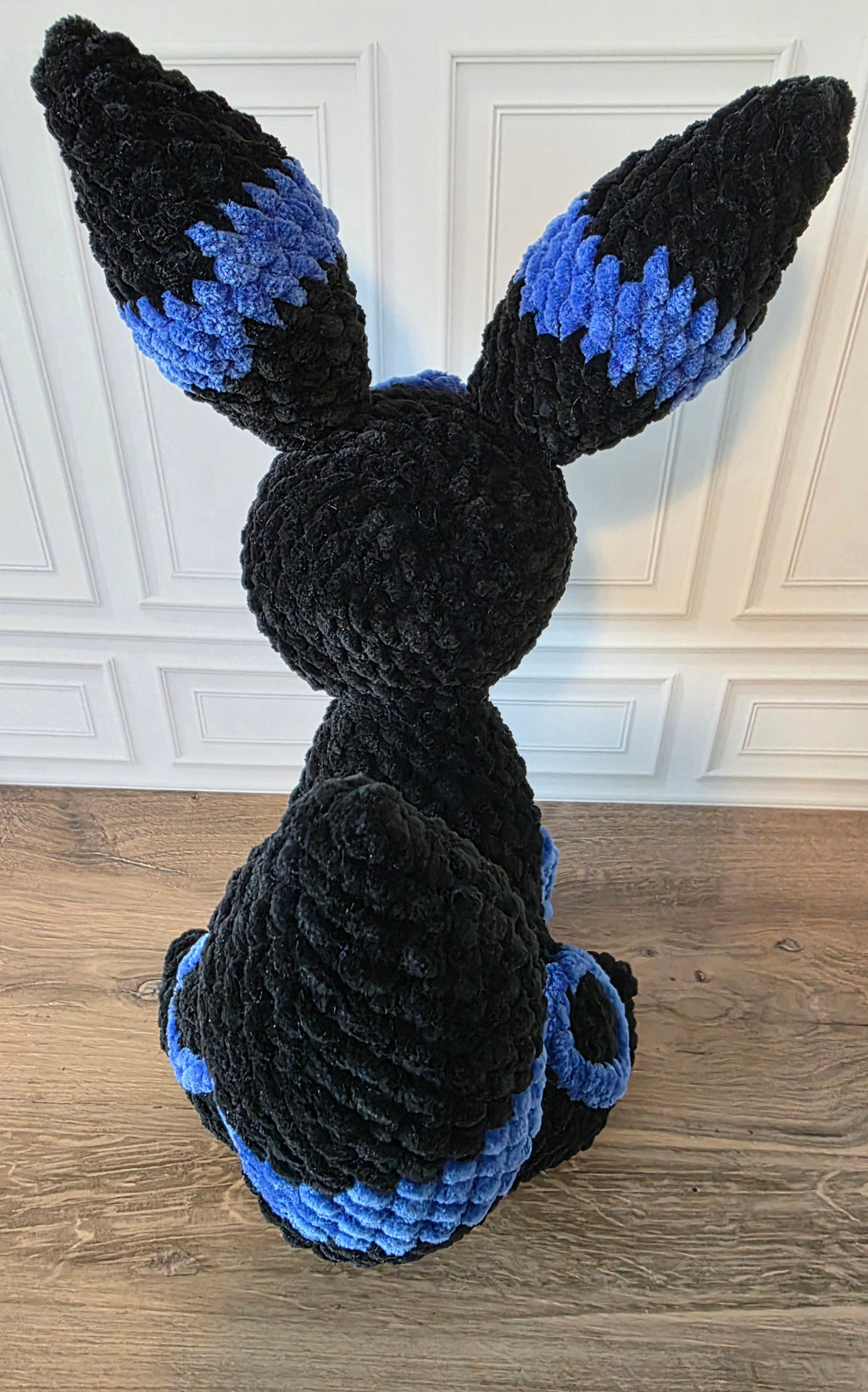 Peluche de dragón sentado con ojos brillantes de colores